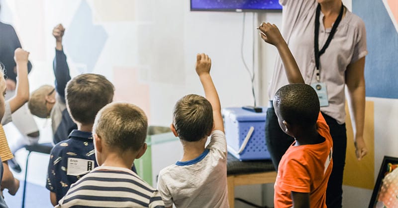 Elementary schoolchildren with raised hands