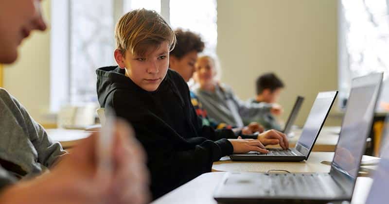 High school student distracted by laptop