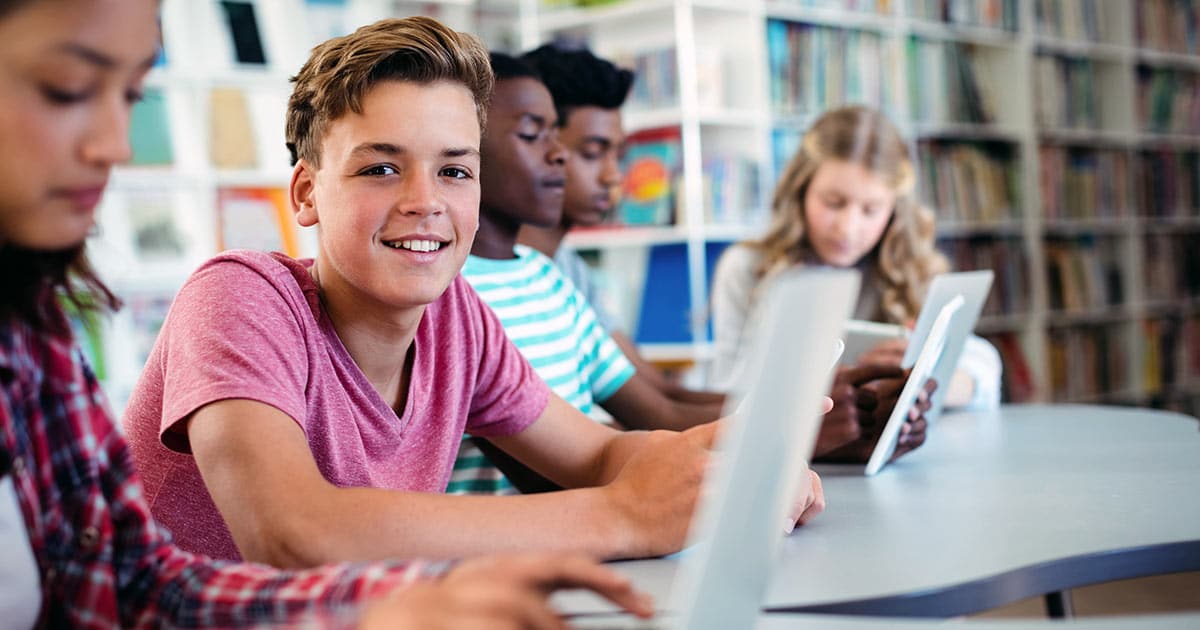 Students using laptops at school in library